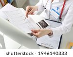 Small photo of Doctor is holding result of decoded cardiogram in his hands