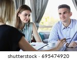 Small photo of Group of people solves the problem in the course of a conversation sitting at a table in a cafe denigrate education teaching each other questions and answers training