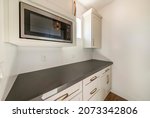 Small photo of White kitchen interior with alcove sleek dark gray kitchen countertop