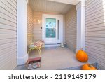 Small photo of House exterior with beige vinyl lap siding and glass storm door over the wreath on the front door