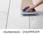 Grouting tiles with a rubber trowel