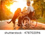 Happy man with his dog at sunset. A guy in a wheelchair.