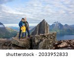Happy family, standing on a rock and looking over Segla mountain on Senja island, North Norway. Amazing beautiful landscape and splendid nature in scandinavian country Norway