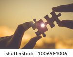 Silhouette Woman hands connecting couple puzzle piece against sunrise effect, businesswoman holding jigsaw with sunset background. Business solutions, target, success, goals and strategy concepts