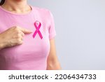 Small photo of Pink October Breast Cancer Awareness month, woman hand hold pink Ribbon and wear shirt for support people life and illness. National cancer survivors month, Mother and World cancer day concept