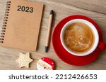 2023 GOAL with notebook, coffee cup, Christmas cookies and pen on wood table. Xmas, Happy New Year, Resolution, To do list, Strategy and Plan concept