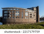 Small photo of Zutphen, The Netherlands - September 2022: Moated apartment building complex with sober Dutch design architecture brick and bombastic style. Housing market and urban development.