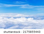 Aerial view of the fluffy cloud on blue sky. High in the Heavens. White Clouds from above.  Top view from an airplane over white clouds in a blue sky. 