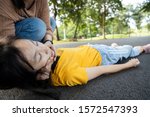 Small photo of Sick teen daughter is fainted and fallen on floor while playing at park,asian mother help,take care,child girl with congestive heart failure,female unconscious lying down on ground suffer heart attack