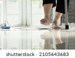 Small photo of Electrical cord or socket cluttered on the floor,feet of senior woman stepping over obstacles,elderly people walking with difficulty in home,concept of danger,injury and risk of accident in falling