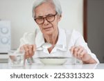 Small photo of Disappointed old people looking at food on dish,eating leftovers,monotonous overnight food,tired expression feel bad,disgusted,Asian senior woman having lack of appetite,diet, nutrition of elderly