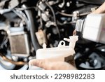 Small photo of Motorcycle mechanic filling coolant in expansion tank after cleaning,check liquid level in coolant reserve tank,cooling system,change the coolant in motorcycle radiator,service and maintenance concept