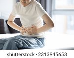 Small photo of Asian teenager girl suffering from abdominal pain,gastritis,peptic ulcer disease,young woman with stomach ache,symptom of gastrointestinal disorders,stomach ulcer,gastric problem,health care,medical