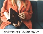 Small photo of A woman is holding a Bible and praying. Studying the Holy Scriptures. Spiritual growth. Faith and spirituality. Bible study and prayer. Oration.