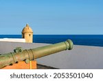 Old iron cannon and guardhouse on the strong walls of the historic fortress of Farol da Barra in the city of Salvador, Bahia