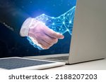 Small photo of Businessman shaking hands with digital partner extending from laptop computer on futuristic background. Artificial Intelligence and Machine Learning Processes for the 4th Industrial Revolution