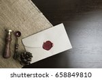 letter seal with wax seal stamp on the wood table and fabric ,  Pine cone on the fabric