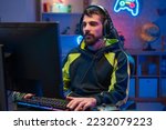 Male gamer focusing on online video games championship, playing action game on online live stream. Caucasian player having fun with virtual esport gameplay tournament on computer. High quality photo