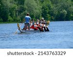 Oarsmen Rowing A Dragon Boat On ...