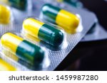 Small photo of Close-up,Green yellow tramadol capsule Pill inside packaging on black background.Pain killer capsules called 'Tramadol