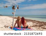 Beach couple back view sun tanning together at tropical fine sand of Sandspur Beach, Bahia Honda Key, Florida Keys
