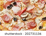 Small photo of Macro of hot stodge pizza with plenty of different types of meat with olive and mushrooms