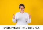 Small photo of latin matured woman portrait with thumbs up on yellow background in Mexico Latin America