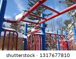 Small photo of Monkey bars covered in snow at a red and blue playground in Pretence Park, Ashland, Wis.