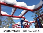 Small photo of Monkey bars covered in snow at a red and blue playground in Pretence Park, Ashland, Wis.