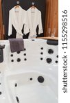Small photo of beautiful white wellness center with spa whirlpool bath with white bathrobes for a couple