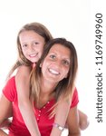 Small photo of Happy beautiful young mother holding back her little cheerful daughter isolated on white