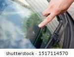 Glazier windscreen on Broken car windshield glass from stone pointed watch of finger hand