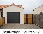 sectional tilting black garage door and entrance gate of modern new house