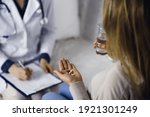 Small photo of Close-up woman-patient holding pills near her doctor, time to take medications, cure for headache or remedy pain killer drugs. Stay at home concept during Coronavirus pandemic and self isolation