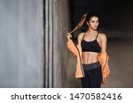 Small photo of Sport, motivation and exercise concept. Determined young sportswoman in black sports bra, leggings, touching braid standing near urban concrete wall, turn aside thoughtful, morning jogging routine