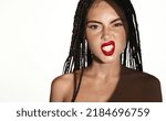Small photo of Sassy woman with dreadlocks, shows her white teeth, attitude pose, has red lipstick, makeup on, stands with bare shoulders against white background