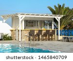 Small photo of Perissa, Greece - July 10 2019: The pool side bar of a holiday apartment building off Firon-Ormou Perissa