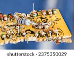 Small photo of E-waste disposal of various electrical components on broken yellow PCB with blue background. Closeup of color coded resistors and silicon diodes on old damaged printed circuit board. Electronic waste.