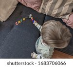 Small photo of Corona virus. A little boy hammers the CORONA letters with a hammer away, a symbol for fighting back against the world menacing infection menace
