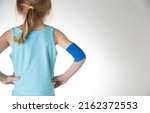 Small photo of Blue elastic bandage on the elbow joint of the child on the arm. White background, close-up.
