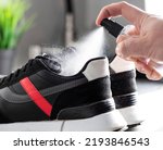 Small photo of treatment of shoes with an antibacterial spray against unpleasant odors and sweat. Destruction of microorganisms, microbes and bacteria, care