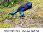 Small photo of A man in boots lies in the forest on the grass. The concept of a lost person, dehydration. Copy space for text, misadventure
