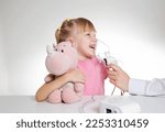 Small photo of A 5-year-old girl breathes into an inhaler to dilute sputum in case of lung diseases. Treatment of cough in children