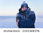 Small photo of Portrait of frozen suffering guy, young handsome freezing man standing walking outdoors at winter snowy cold frosty day, shaking, trembling, shivering because of extreme low temperature in jacket, hat
