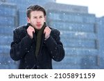 Small photo of Portrait of frozen suffering guy, young handsome freezing man walking outdoors at winter snowy cold frosty day, shaking, trembling, shivering because of low temperature in coat, worker going to job
