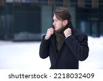 Small photo of Portrait of frozen suffering guy, young handsome freezing man walking outdoors at winter snowy cold frosty day, shaking, trembling, shivering because of low temperature in coat, worker going to job