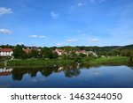 Small photo of An idyllic village is reflected in the water of the pent-up Fulda.