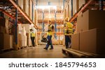 Small photo of Retail Warehouse full of Shelves with Goods in Cardboard Boxes, Workers Scan and Sort Packages, Move Inventory with Pallet Trucks and Forklifts. Product Distribution Logistics Center.