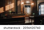 Small photo of Empty American Style Courtroom. Supreme Court of Law and Justice Trial Stand. Courthouse Before Civil Case Hearing Starts. Grand Wooden Interior with Judge's Bench, Defendant's and Plaintiff's Tables.
