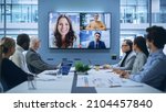 Small photo of Video Conference Call in Office Boardroom Meeting Room: Executive Directors Talk with Group of Multi-Ethnic Entrepreneurs, Managers, Investors. Businesspeople Discuss e-Commerce Investment Strategy